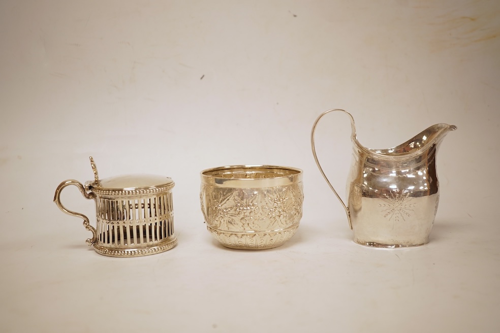 A George III silver helmet shaped cream jug, marks rubbed, 10cm(a.f.), together with a later Victorian silver sugar bowl and similar pierced silver mustard pot, no liner.